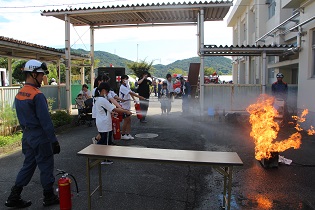 水消火器による初期消火訓練の写真です。