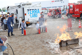 水消火器による初期消火訓練の写真です。