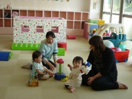 支援センターの部屋の中で遊ぶ親子の写真